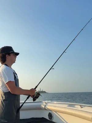Theo Ball fishing off the bow of a boat at dusk